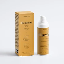Illuminate vitamin C serum bottle and carton on mustard yellow backdrop