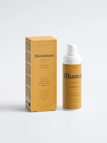 Illuminate vitamin C serum bottle and carton on mustard yellow backdrop