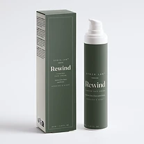 Rewind peptide firming face cream bottle and carton on deep sage green backdrop