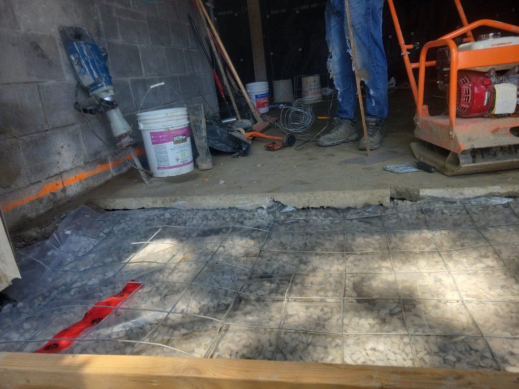 Rebar mesh and drain stack rough-in ahead of the concrete pour.