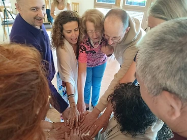 Group standing in a circle with hands joined in unity