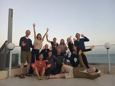 Community group photo on a rooftop terrace at twilight