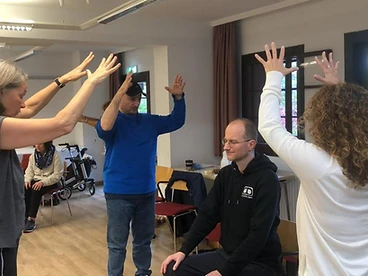 Indoor Qigong practice session with raised arms