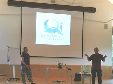 Workshop presentation with Hunyuan Qi Therapy logo on screen