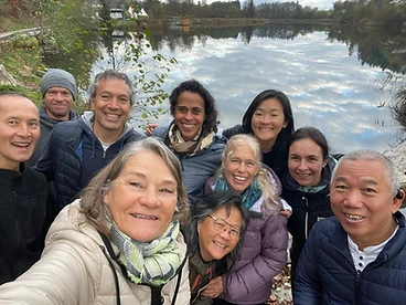 Group selfie by a lake with autumn foliage