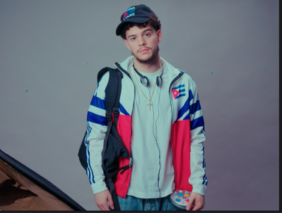 Retrato de Yuma con gorra CUBA y chaqueta deportiva a bloques de color