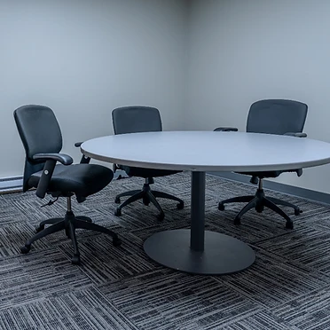 Conference room with circular meeting table and ergonomic chairs