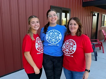 Three guests in Patriot Ranch shirts gathered on the patio