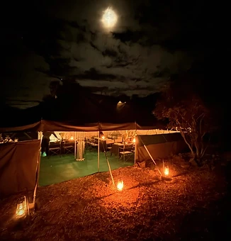The dining tent by moonlight and lantern glow