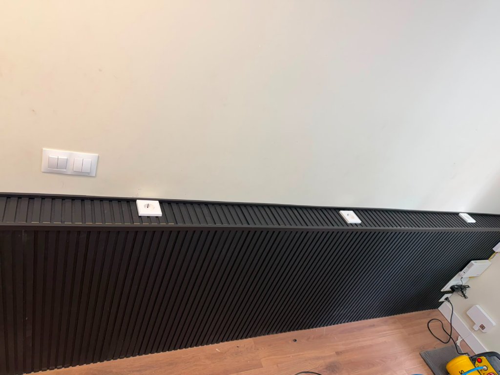 Panel decorativo negro con enchufes e interruptores