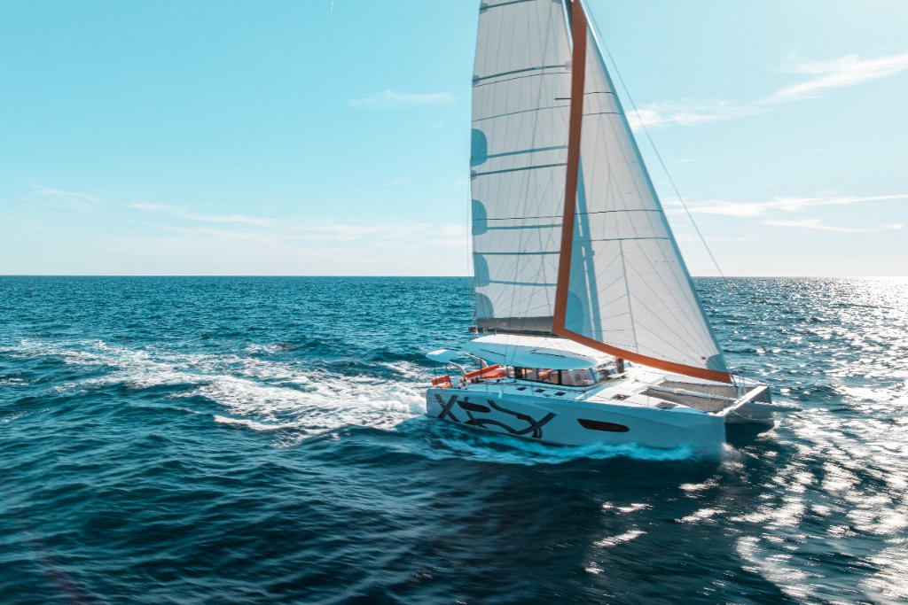 Excess catamaran at full speed cutting through turquoise Mediterranean waters