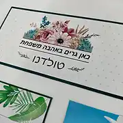 שלט לדלת כניסה מעוצב בסגנון כפרי ורומנטי, מלבני עם מסגרת כהה ורקע לבן ועדין עם נקודות קטנות. בחלקו העליון של השלט מופיע איור צבעוני של זר פרחים בסגנון ציור בצבעי מים בגווני ורוד, סגול וירוק. במרכז השלט מופיע הכיתוב 'כאן גרים באהבה משפחת טולדנו' בגופן שחור ונקי, המעניק מראה אישי וחם. זהו שלט אישי ומרגש שמתאים במיוחד כשלט לדלת הבית או שלט לכניסה, המקבל את פני הבאים באווירה נעימה ומזמינה. שלטים מסוג זה הם חלק מהמומחיות של סטודיו 'שלט לדלת' המתמחה בעיצוב שלטים איכותיים לבית, לחדרי ילדים ולמשרדים, תוך שימוש בחומרים עמידים ועיצובים מקוריים שהופכים כל שלט מעוצב לפריט דקורטיבי בולט.