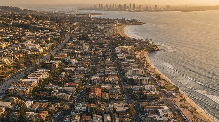 Aerial view of the Southern California coastline and dense residential neighborhoods at golden hour