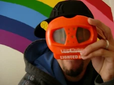 Miguel looking through a View-Master with a rainbow mural behind