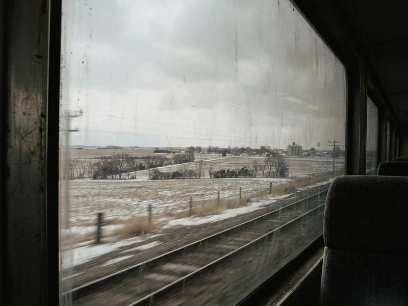 Flat midwestern landscape seen from a moving train in winter