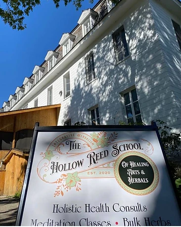 The Hollow Reed School sign in front of the historic monastery building