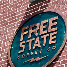 Free State Coffee Co circular sign mounted on the brick wall