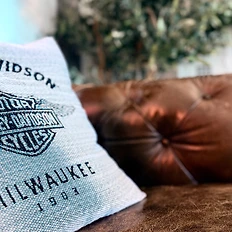 Harley-Davidson logo pillow on tufted leather sofa