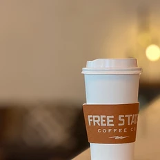 Free State coffee cup on table with books
