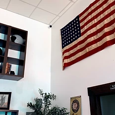 Interior wall with Harley-Davidson helmets, aged American flag, and restroom sign