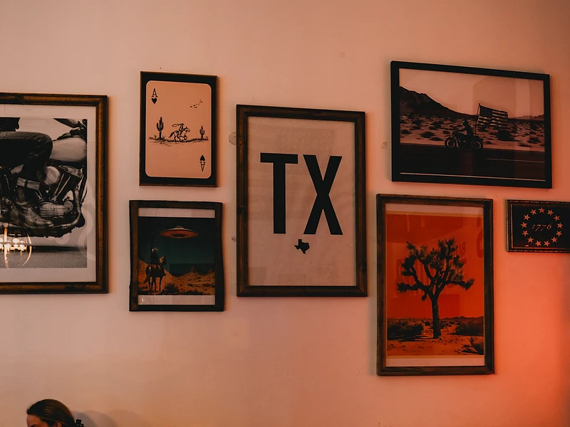 Gallery wall of Texas and motorcycle prints at Free State Coffee Co