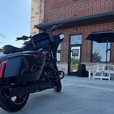 Black motorcycle parked in front of the brick exterior of Free State Coffee Co