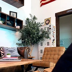 Leather chesterfield sofa with Harley-Davidson pillow and olive tree
