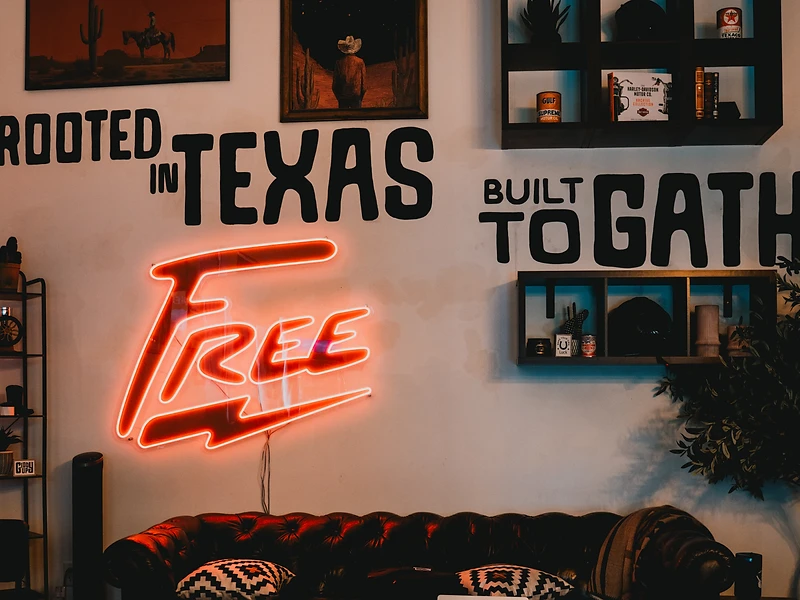 Tufted leather sofa and neon Free sign in the Free State lounge