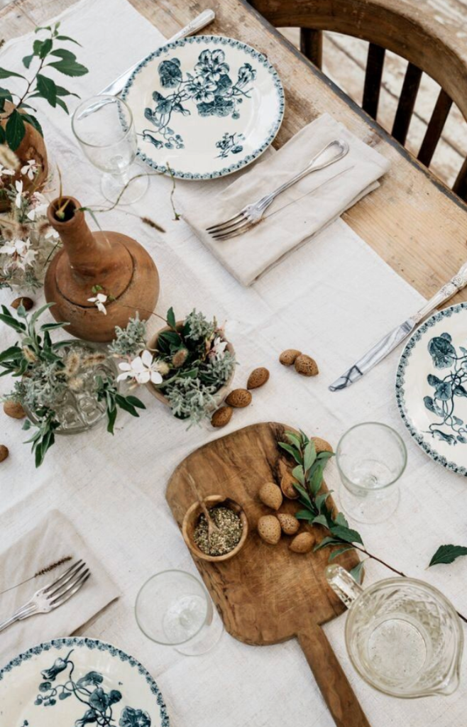 Top-down tablescape with blue botanical plates and a grazing board