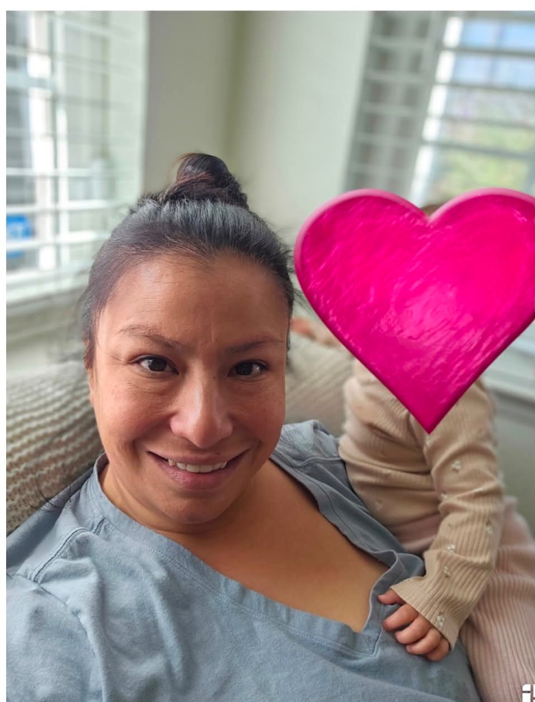 Briza with a child holding a pink heart