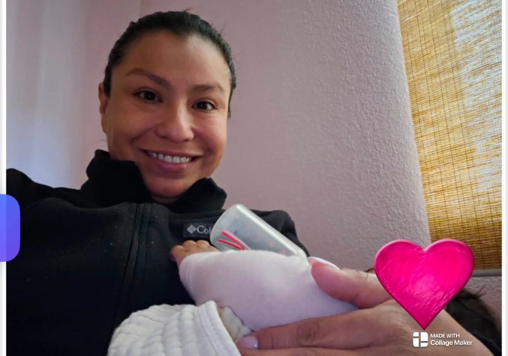 Briza holding a newborn with a heart