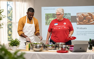 An LHI instructor and a participant preparing food together during a culinary medicine workshop.