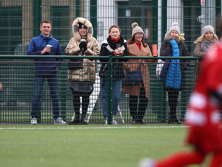 Spectators behind a Respect barrier watching an OYFL youth match