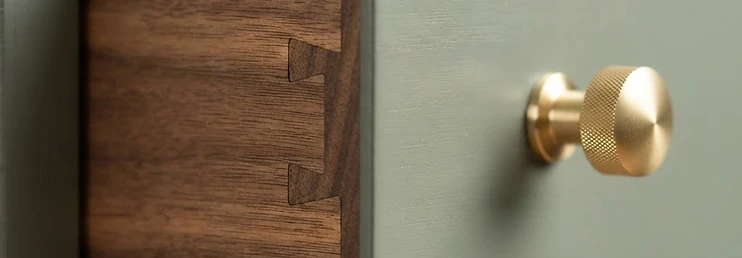 Close-up of premium cabinet dovetail drawer construction with solid wood and brushed gold hardware