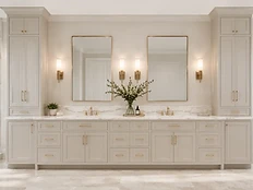 Custom wall-to-wall bathroom vanity with greige cabinetry, tall linen towers, dual sinks and marble countertops