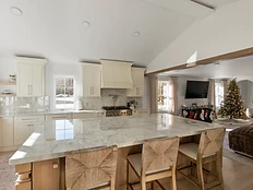 Transitional kitchen with off-white shaker cabinetry and warm wood waterfall island