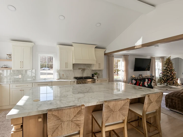 Transitional kitchen with off-white shaker cabinetry and warm wood waterfall island