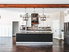 Two-tone kitchen with white cabinetry and dark island