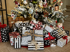 Flocked Christmas tree with warm white lights and coordinated black, white, and red wrapped presents