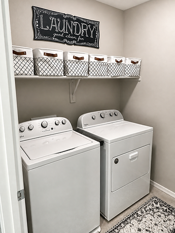 Laundry room with washer, dryer, and storage bins