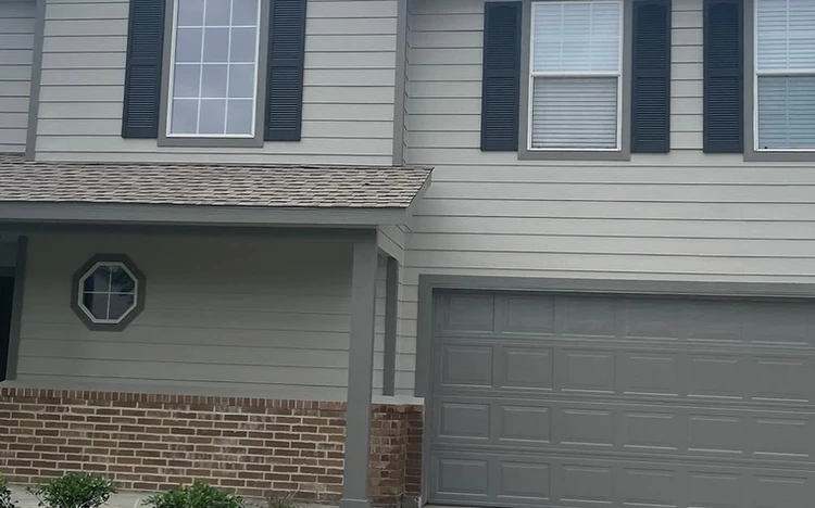 Two-story home exterior with refreshed grey siding and shutters painted by Arc Painting Solutions in Spring, TX