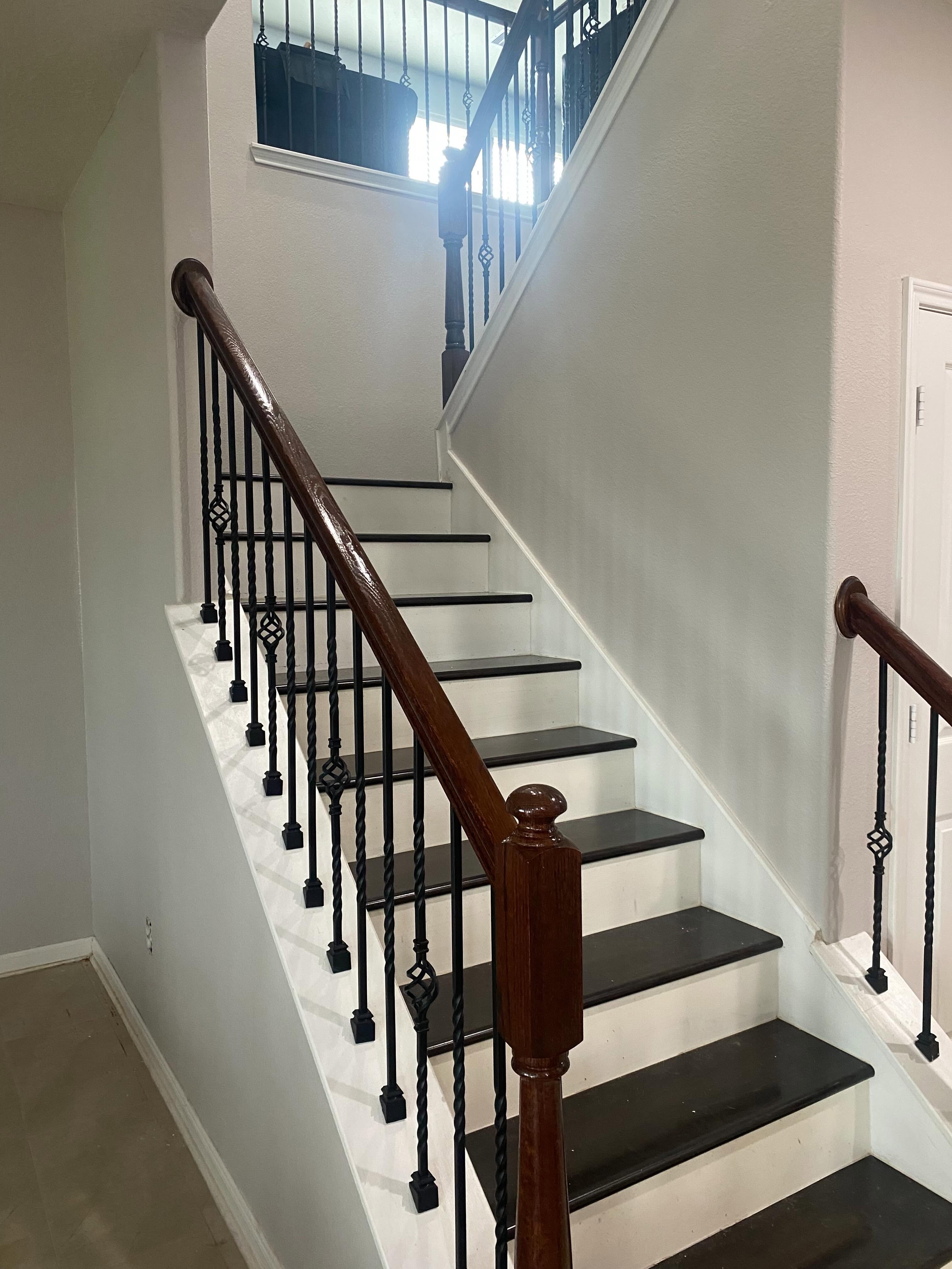 Staircase with white risers and black balusters by Arc Painting Solutions in The Woodlands, TX