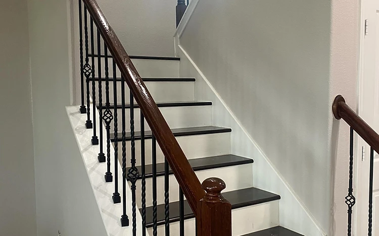Staircase with white risers and black balusters painted by Arc Painting Solutions in Spring, TX