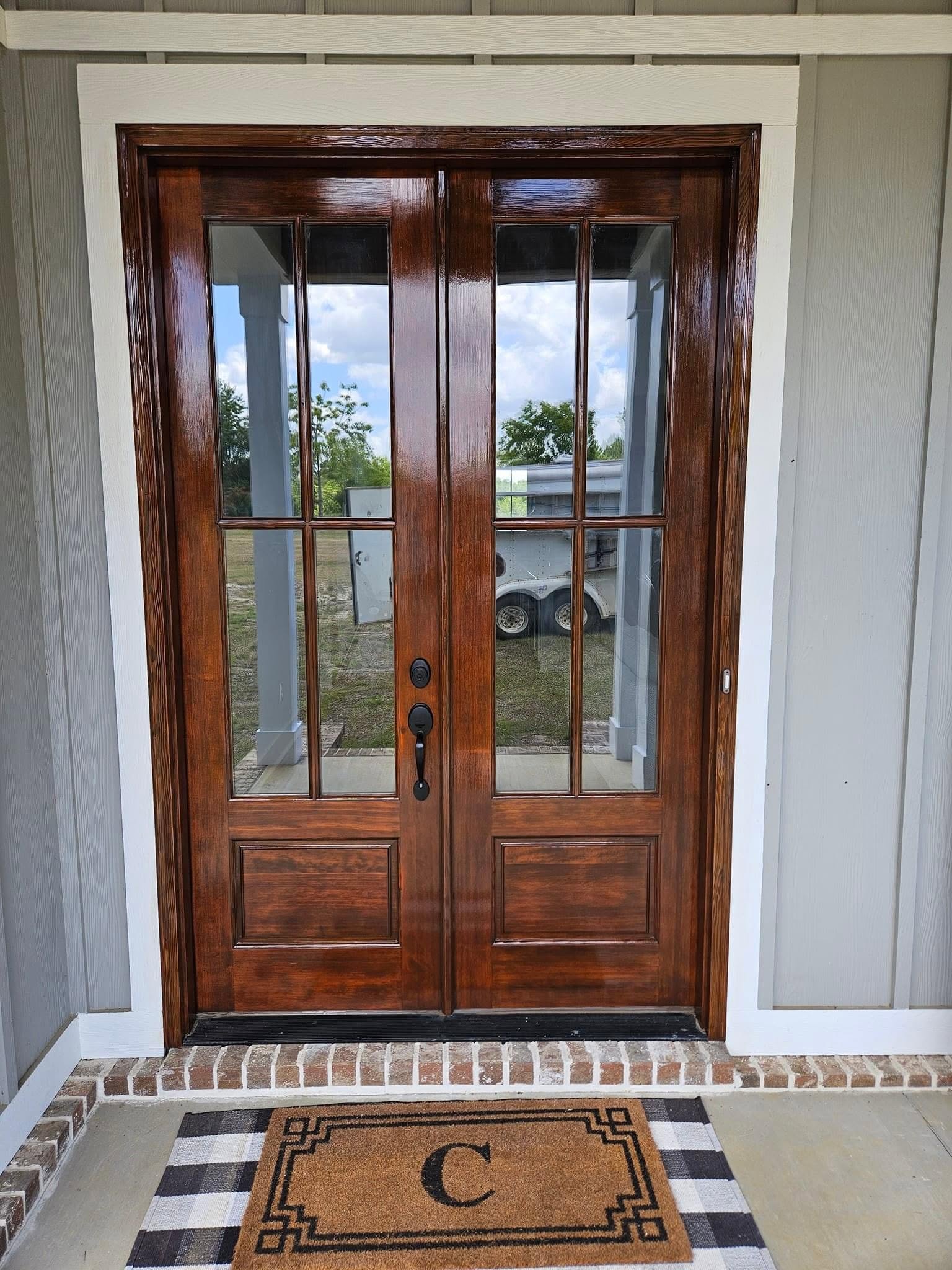 Refinished walnut double entry doors by Arc Painting Solutions in The Woodlands, TX