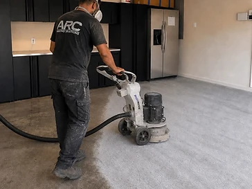 Arc Painting Solutions crew member diamond-grinding a garage floor to prep for epoxy coating