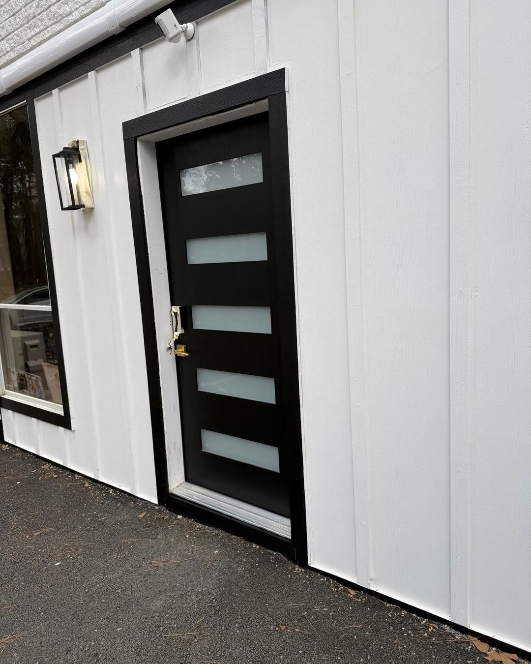 Matte black entry door with painted frame and siding by Arc Painting Solutions in The Woodlands, TX