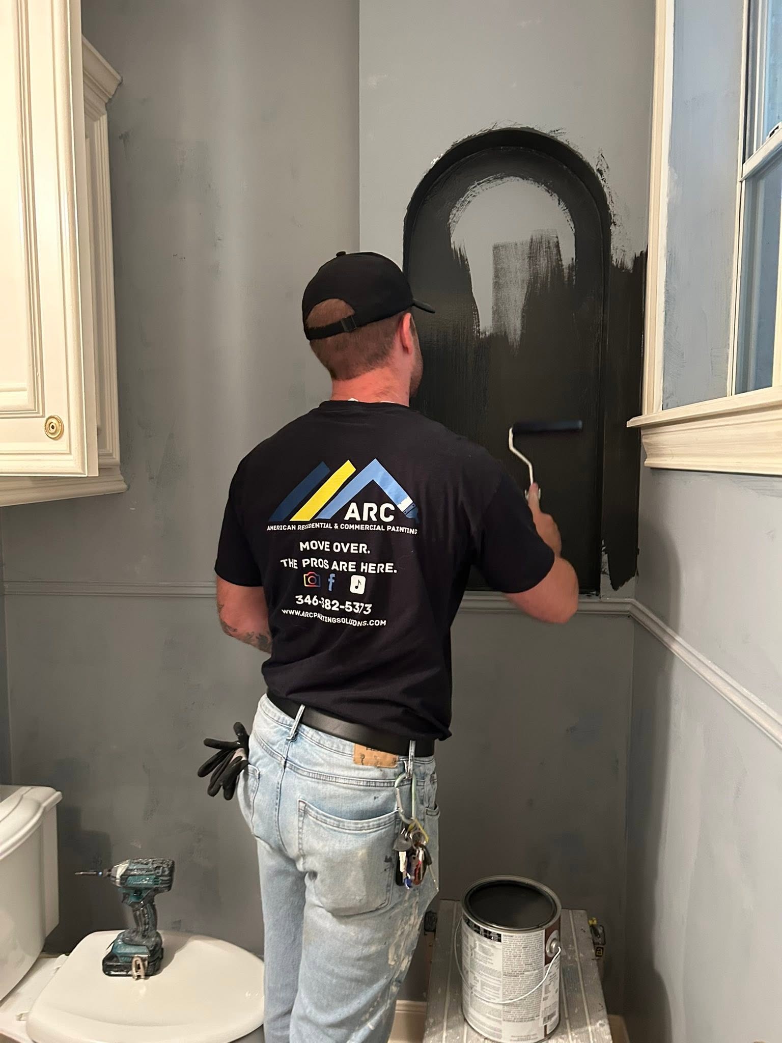 Arc painter rolling a dark accent niche by Arc Painting Solutions in The Woodlands, TX