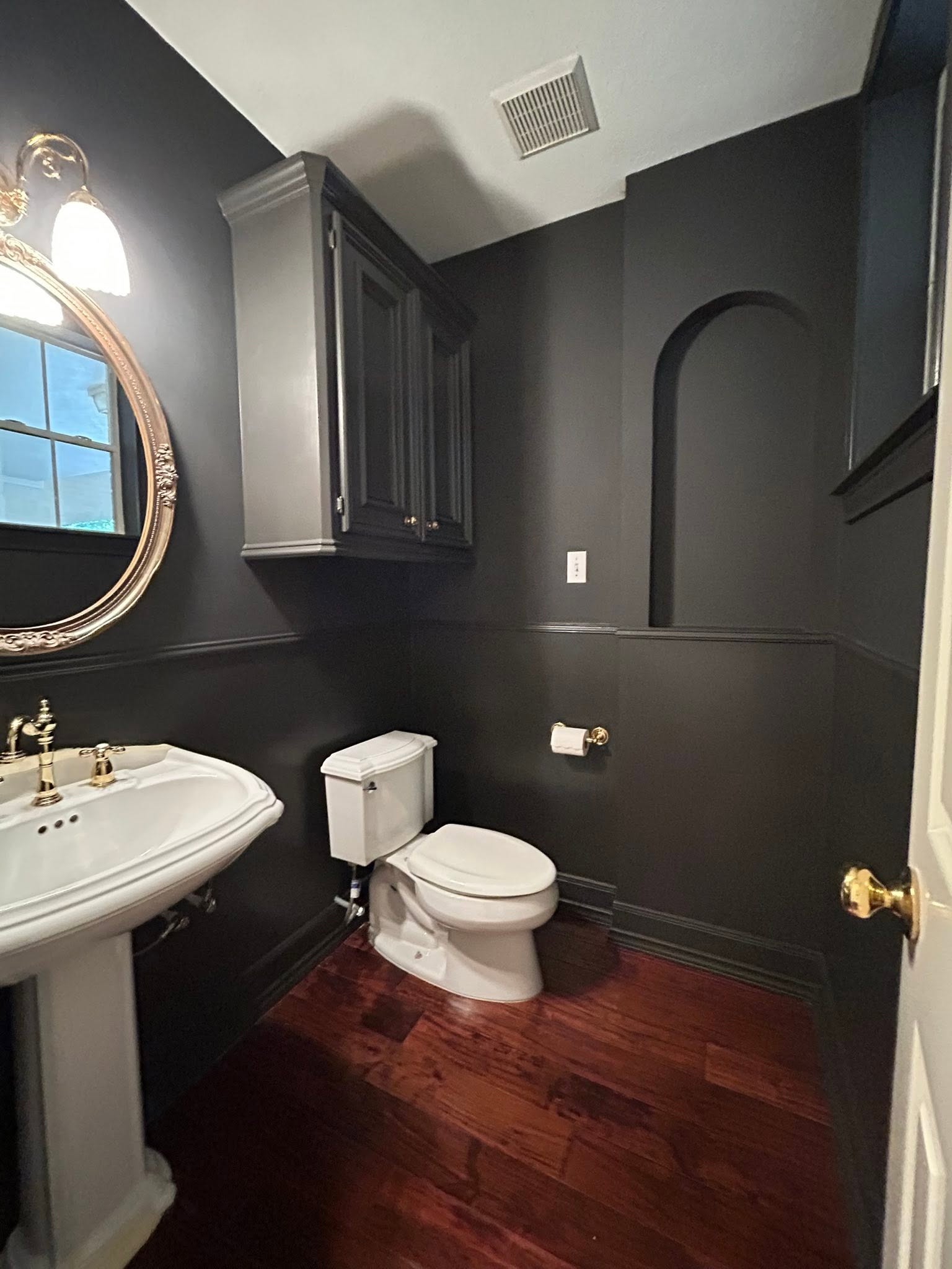 Moody charcoal powder room with gold accents by Arc Painting Solutions in The Woodlands, TX