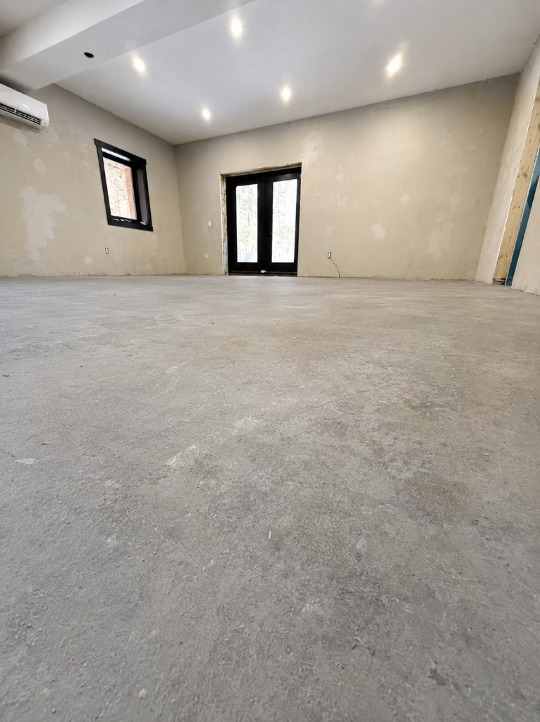 Unfinished concrete slab before epoxy flooring by Arc Painting Solutions in Houston
