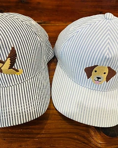 Two striped embroidered hats with duck and dog designs